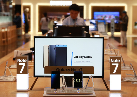 10일 오후 서울 삼성전자 서초사옥 딜라이트샵에서 한 고객이 갤럭시노트7 제품을 살펴보고 있다.  삼성전자 협력사 관계자는 이날 최근 미국을 중심으로 발화 보고가 잇따른 갤럭시노트7에 대해 &quot;삼성전자가 생산을 일시 중단했다&quot;고 전했다. 사진=연합뉴스